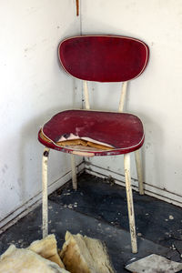 Empty chair on table against wall