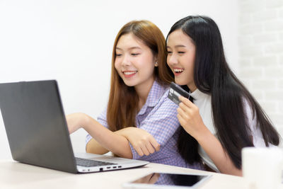 Smiling young woman using mobile phone