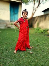Portrait of smiling girl wearing sari standing in yard