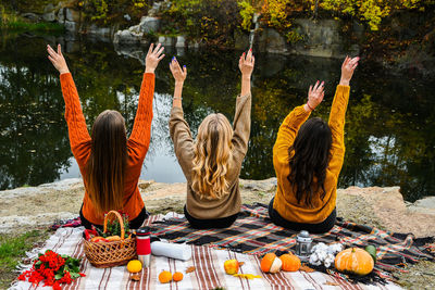 Three women best friends at autumn picnic in the park. colorful plaid, thermos and pumpins. friends