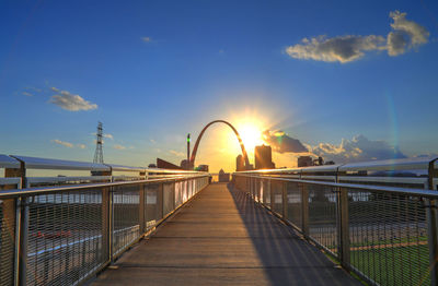 Footbridge against sky during sunset