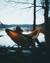 Man sitting on boat against sky