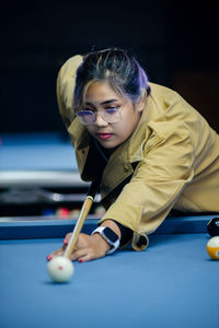 Young woman playing pool