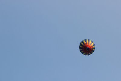 Low angle view of hot air balloon against clear blue sky