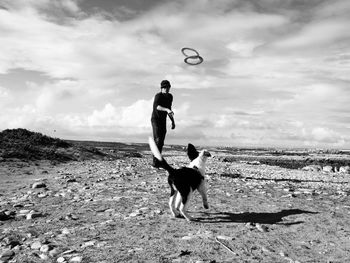 Man playing with dog on field