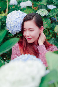 Mid adult woman by flowering plants in park