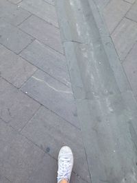 Low section of person standing on tiled floor