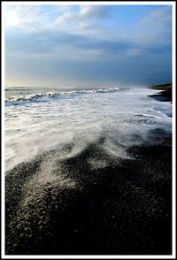 Scenic view of sea against cloudy sky