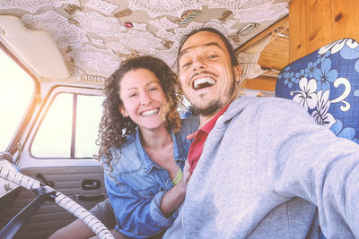 Portrait of smiling couple sitting in mini van