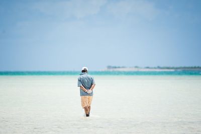 Rear view of man walking on beach