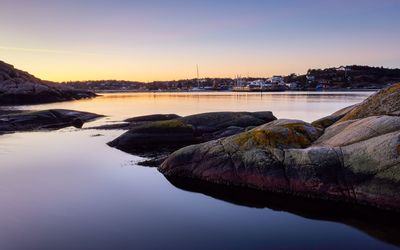 Scenic view of river against sky at sunset