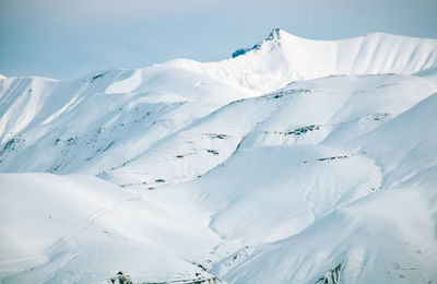 Scenic view of snow covered mountains against sky