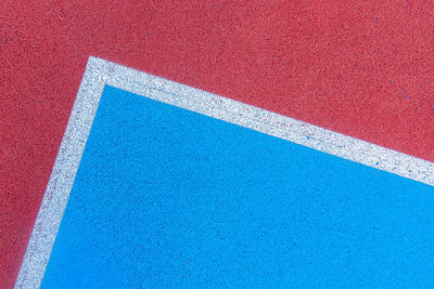 Colorful sports court background. top view to red and blue field rubber ground with white and lines