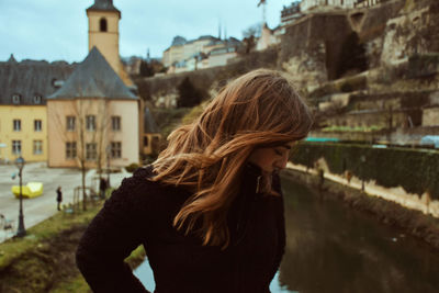 Close-up of woman tossing while standing in city