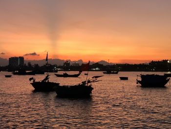 Silhouette ship in sea against sky during sunset