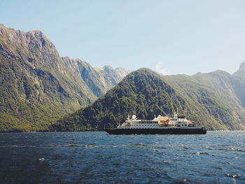 Cruise ship against mountains at milford sound