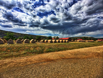 Hay bales on field against sky