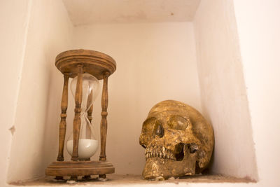 Close-up of human skull on old table against building