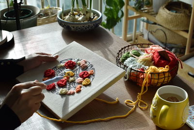 Cropped hand of woman with cake on table