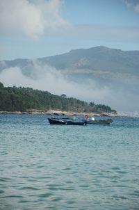 Boats in sea against sky