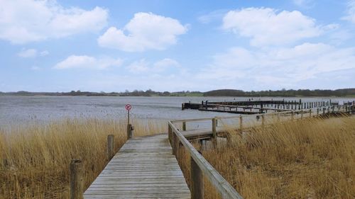 Pier over lake against sky