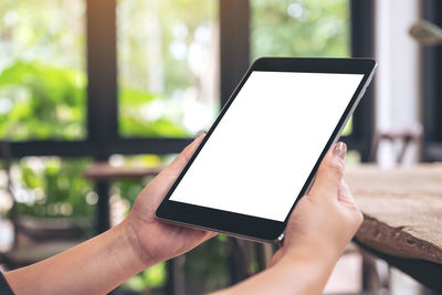 Close-up of hands using digital tablet at table