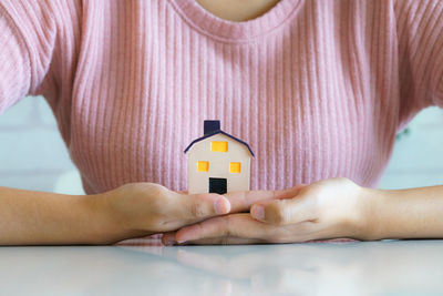 Close-up of woman hand holding yellow house