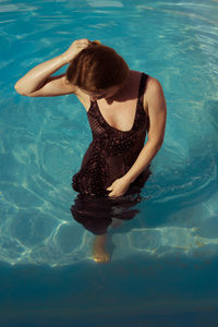 Rear view of woman swimming in pool