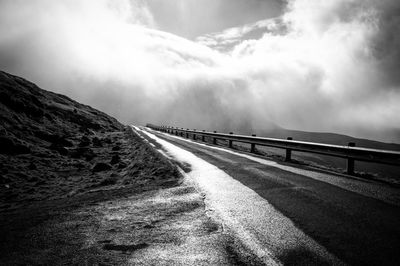 Road by mountain against sky