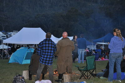 Group of people sitting in tent against mountain