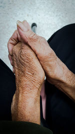 Midsection of senior woman with hands clasped