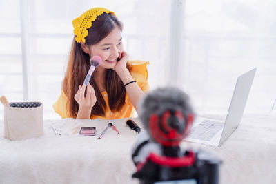 Portrait of woman using phone on table