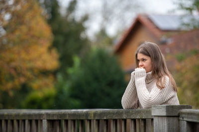 Portrait of young woman looking up outdoors