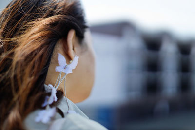 Close-up portrait of a woman focus on butterfly earrings.