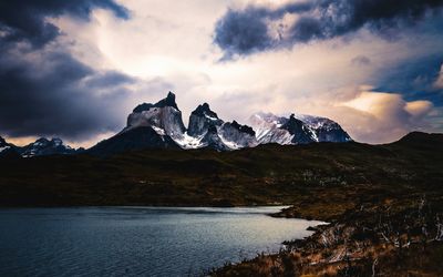 Scenic view of mountains and lake against cloudy sky