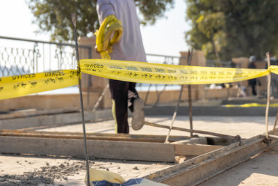 Selective focus of danger yellow cord in a construction site with an unrecognizable man working 