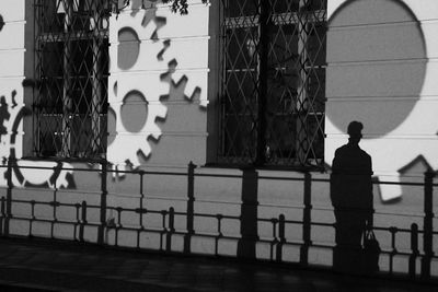 Rear view of man standing by railing in city