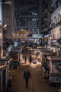 People walking on street amidst buildings in city
