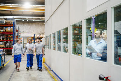 Employees walking together in production hall at factory