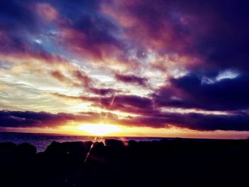 Scenic view of dramatic sky over silhouette landscape