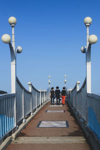 People walking on street against clear sky