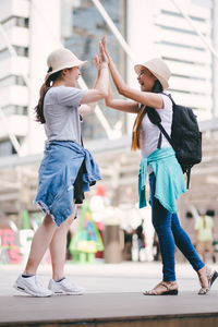 Tourists doing high five while standing in city