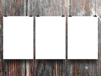 Close-up of old wooden post against white wall