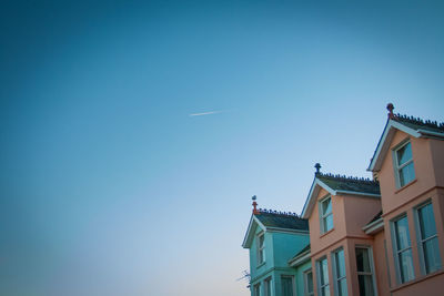 Low angle view of houses against clear blue sky