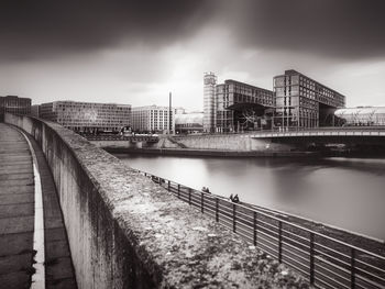 Bridge over river against cloudy sky