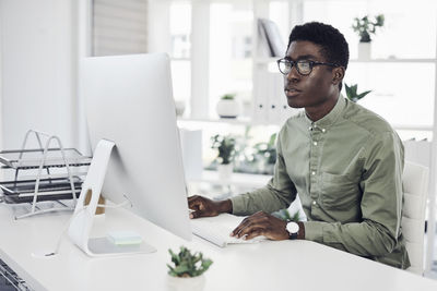 Man using mobile phone while sitting on table