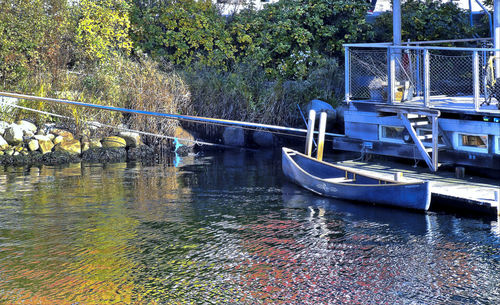 Boats moored in canal by river