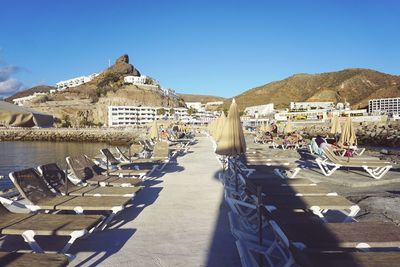 Empty lounge chairs with closed parasols on promenade