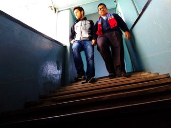 Low angle view of friends standing on staircase