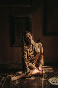 Young woman sitting on floor at home